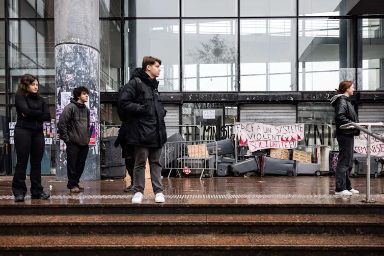 Des étudiants se tiennent devant le campus universitaire de Lille lors d’un blocus dans le cadre du mouvement contre la réforme des retraites proposée par le gouvernement et en faveur des droits des femmes lors de la Journée internationale de la femme le 8 mars 2023
