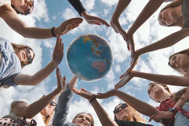 Concept de conservation de la Terre. 11 filles entourent le globe terrestre tournant de leurs mains de paume.