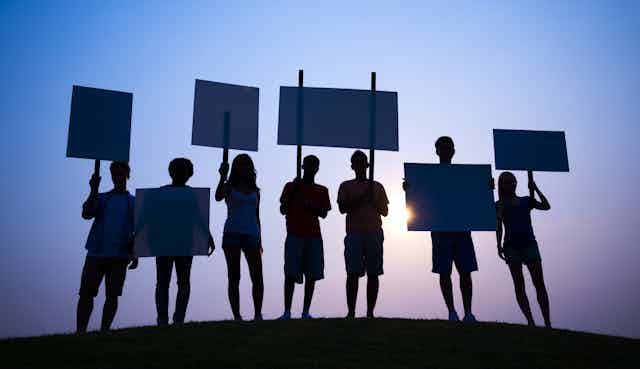 Group of young protesters silhouetted