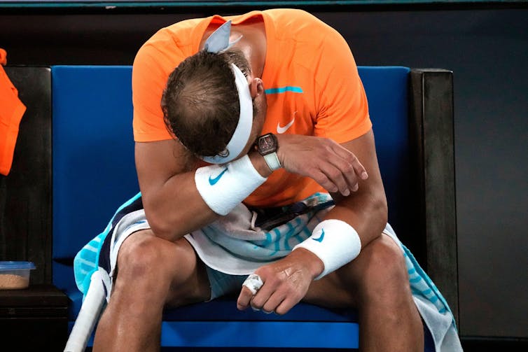 Rafa Nadal covers his face in despair after losing in the second round of the 2023 Australian Open.