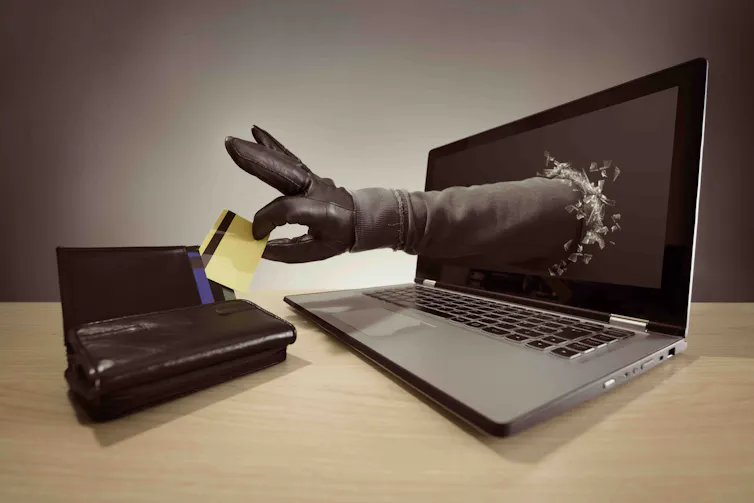 bras sortant d’un écran pour voler une carte bancaire