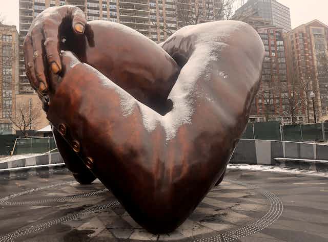 A bronze sculpture of arms embracing was built in a park. 