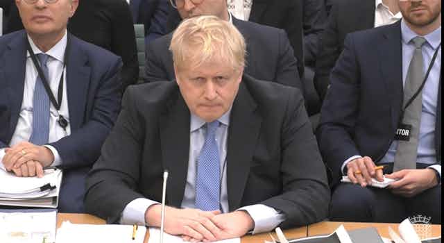 Boris Johnson sitting in a parliamentary committee room giving evidence.