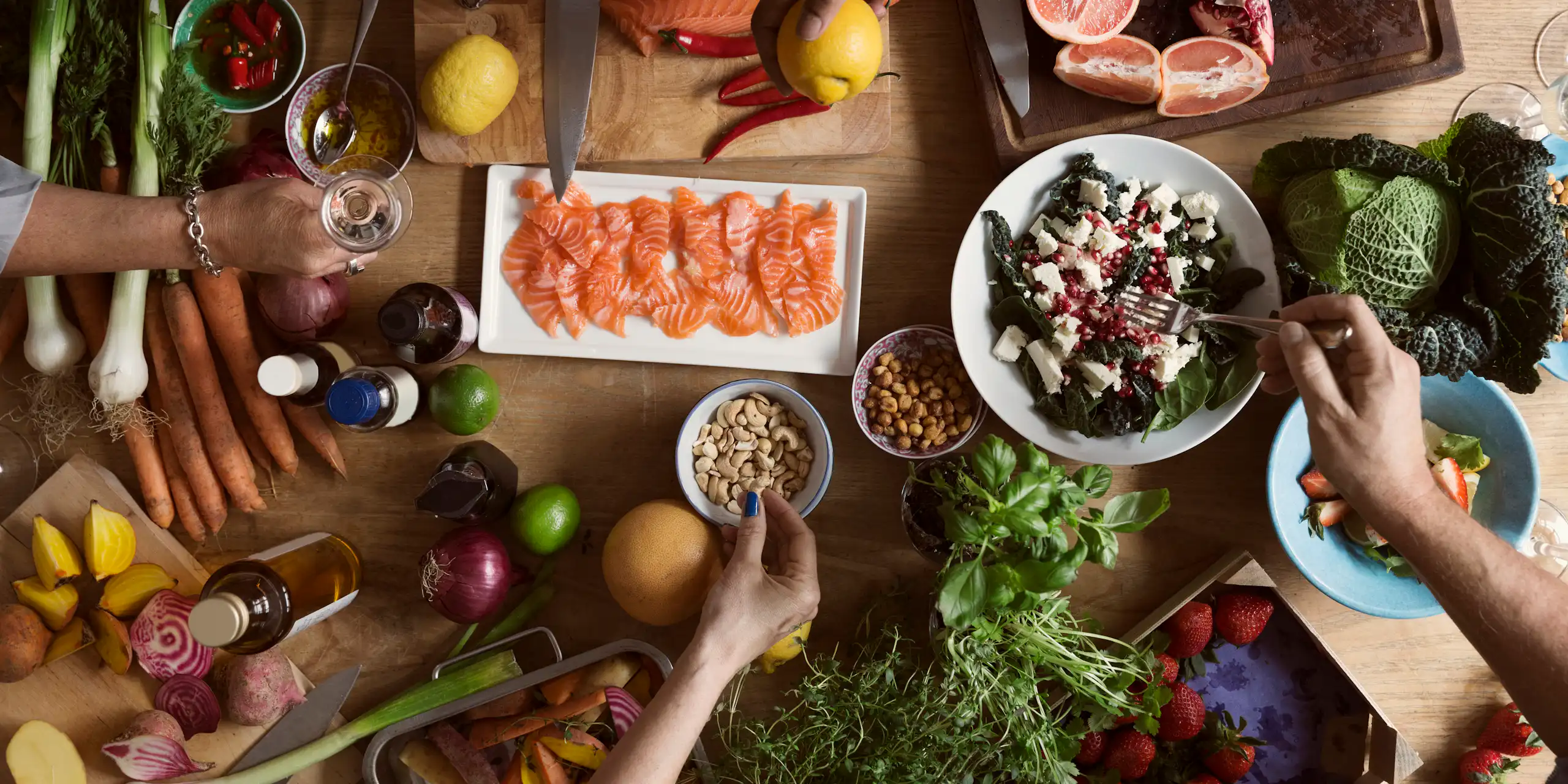 Una mesa con mariscos, vegetales y frutas.