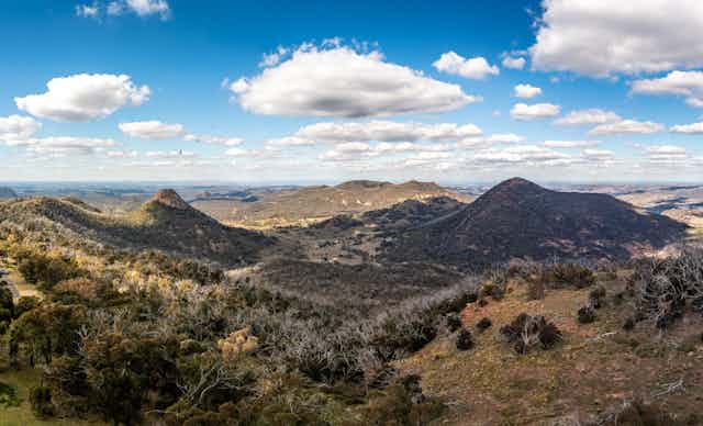 A rugged landscape of rolling hills and brown grass