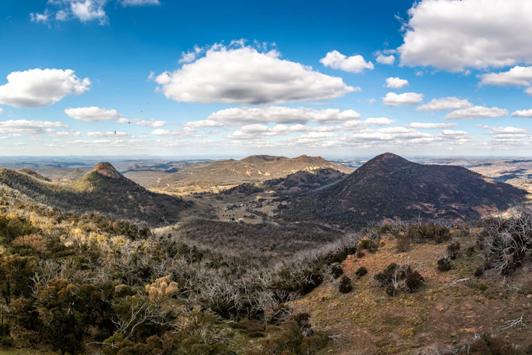 A rugged landscape of rolling hills and brown grass