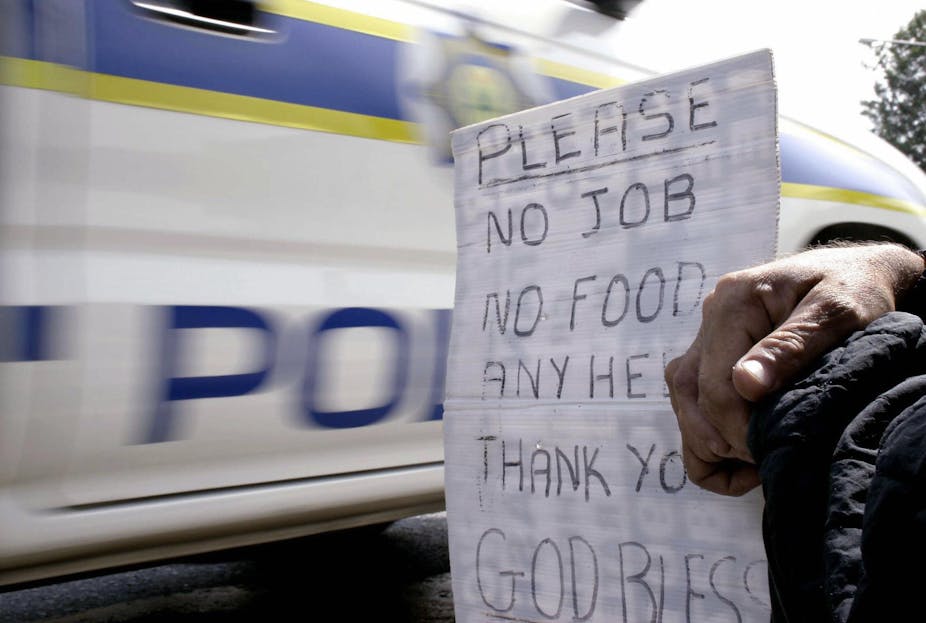 close up of a sign held by a beggar