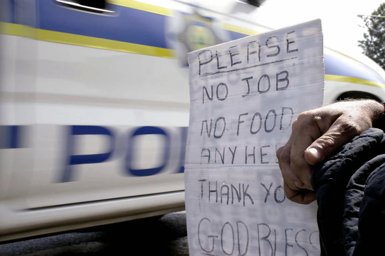 close up of a sign held by a beggar
