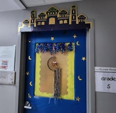 A door seen decorated with a hanging crescent moon.