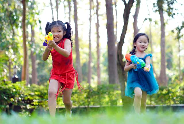 two girls with colorful water guns