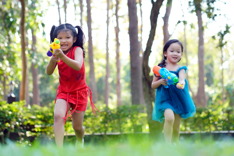 two girls with colorful water guns