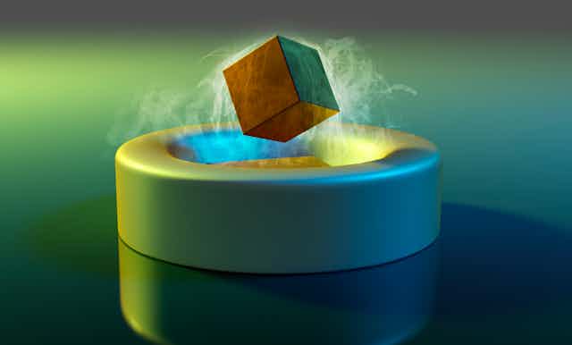A cube floating above a magnet.