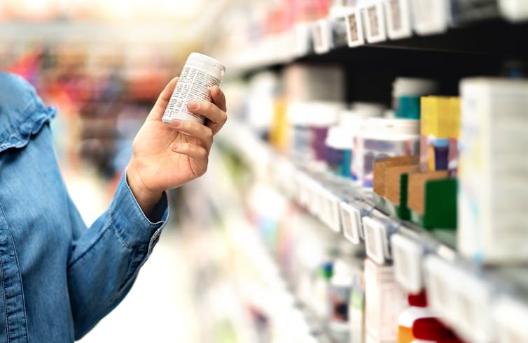 Person selects pill container from store shelf