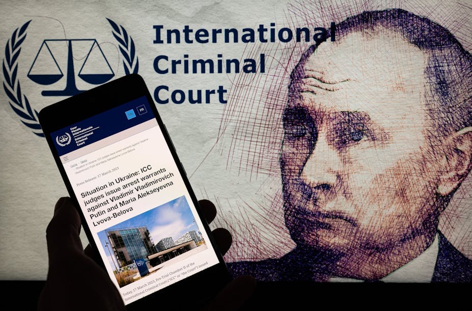 Montage représentant Vladimir Poutine, le logo de la CPI et un smartphone affichant l'information de l'émission du mandat d'arrêt à son encontre