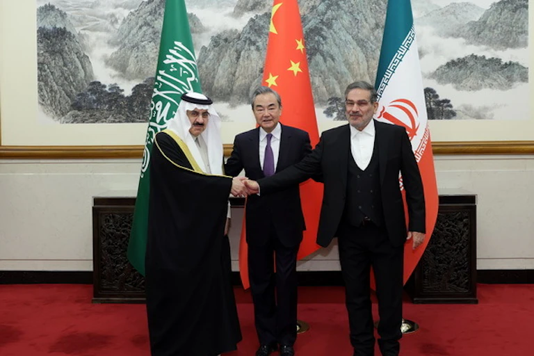World leaders shake hands in front of flags of Saudi Arabia, China and Iran