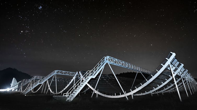 A nighttime view of white curved pipes arranged in a grid pattern