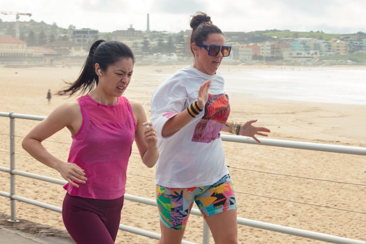 Two women running near a beach.