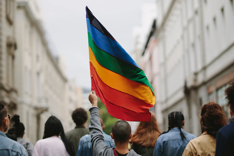 Person holding a rainbow flag at a protest march