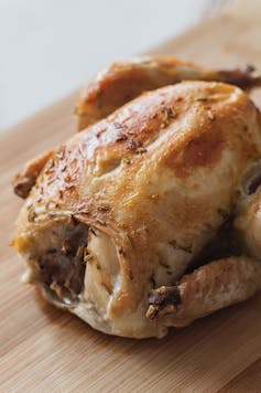 a roast chicken on a wooden board