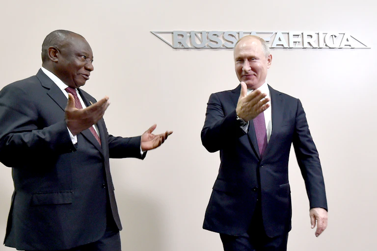 A man, right, points the way with his right hand to another, who has both hands in a surprised gesture.