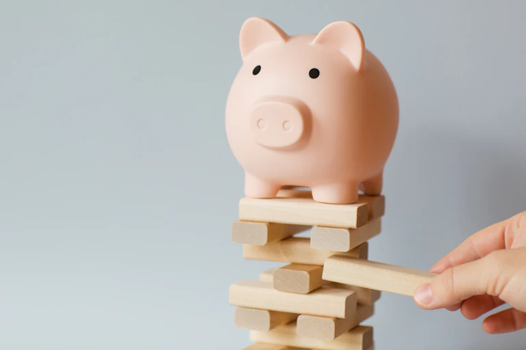 Piggy bank on top of a jenga game