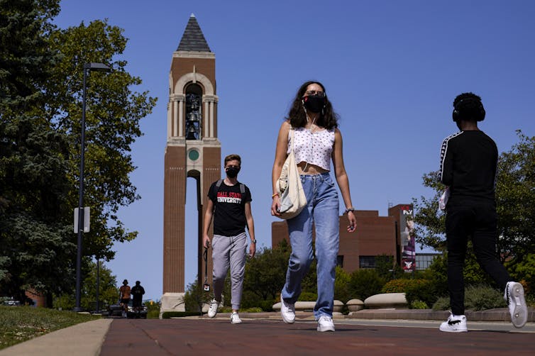 Students seen walking through a campus with face masks on.