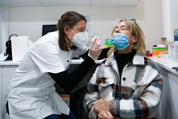 Une pharmacienne fait le prélèvement nasal à une cliente