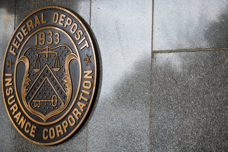 The Federal Deposit Insurance Corporation's round logo on a shiny stone wall