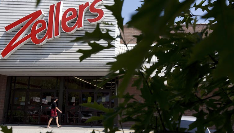A person walks by a Zellers storefront
