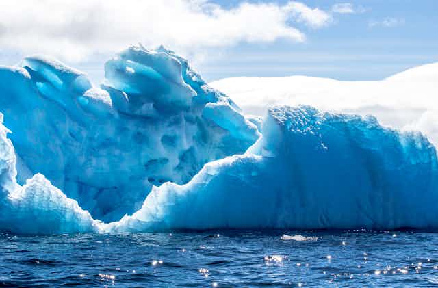 An iceberg in the Antarctic, with seawater in the foreground 