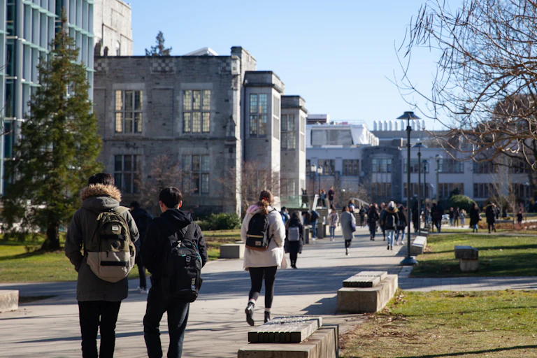 Students walk along a pathway at a university campus.