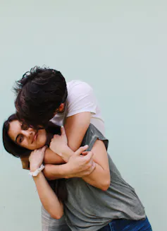 A young couple hug.