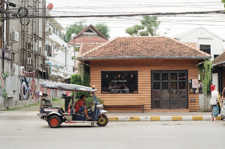 A coffee shop and a small vehicle in a Thai class=