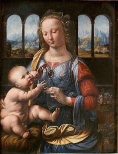 A da Vinci painting showing the baby Jesus and Madonna. He sits on her lap and looks up at her.