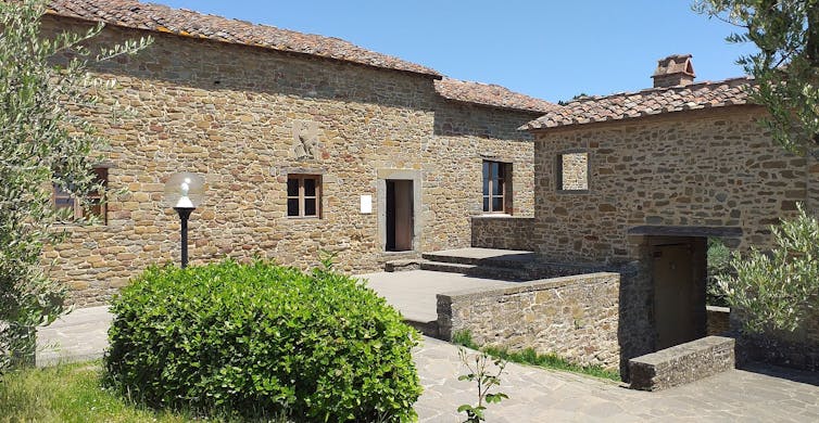 A stone house with courtyard photographed on a sunny day.