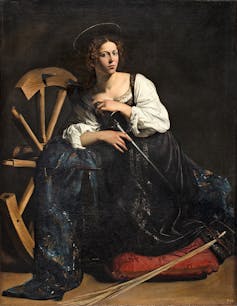 A painting of St Catherine shows her next to a large wooden wheel, holding a slender sword.