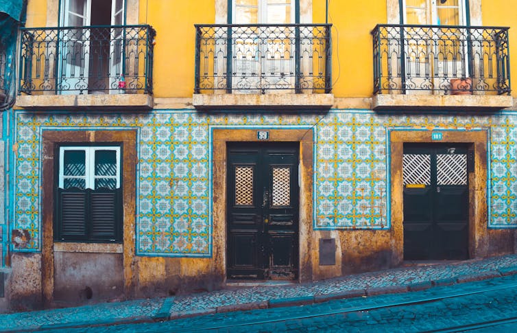 A street view of a tiled building on a steep incline.