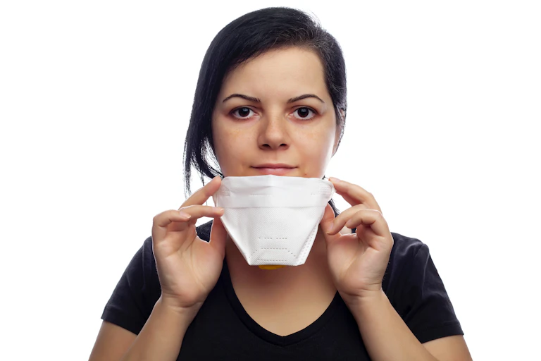 Une jeune femme enlève son masque FFP2