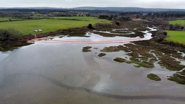 Aerial view of a river crossed by red floats