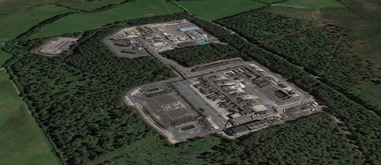 satellite shot of industrial buildings surrounded by trees