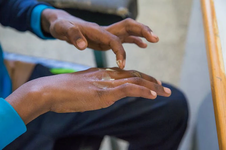 Homme appliquant de la crème sur le dos de sa main