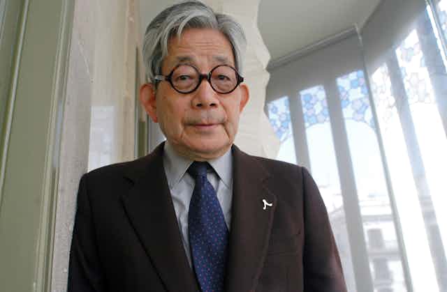 An old man in a suit with round glasses. 