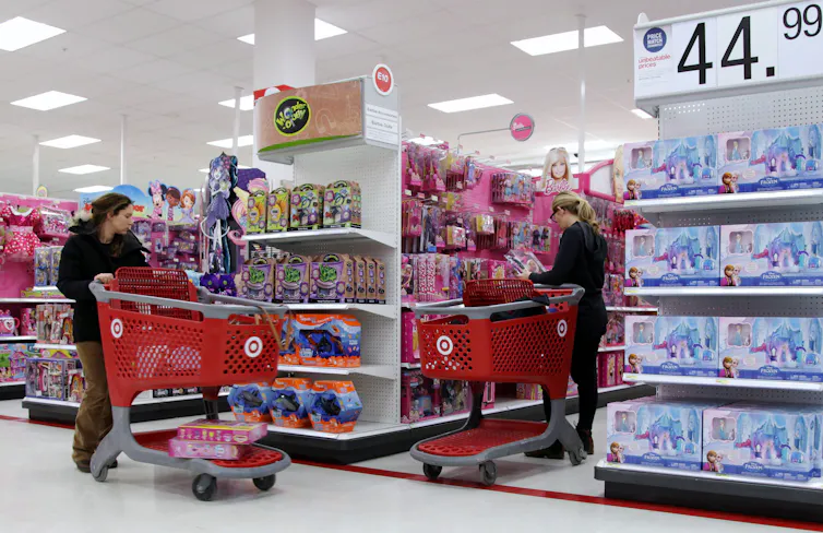 Shoppers pushing shopping carts down the aisles of a retail store