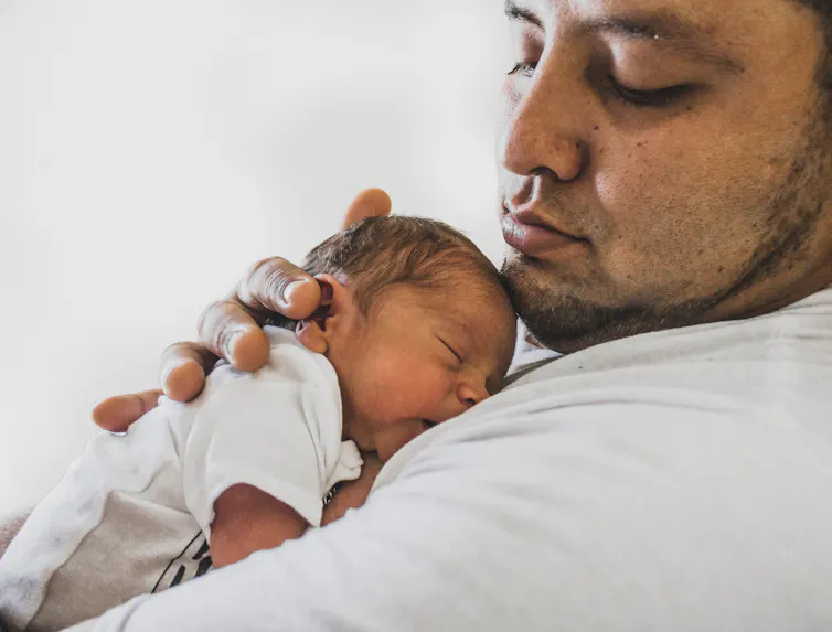 A father seen with an infant.