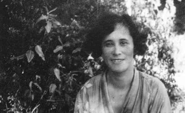 A woman seen smiling outdoors.