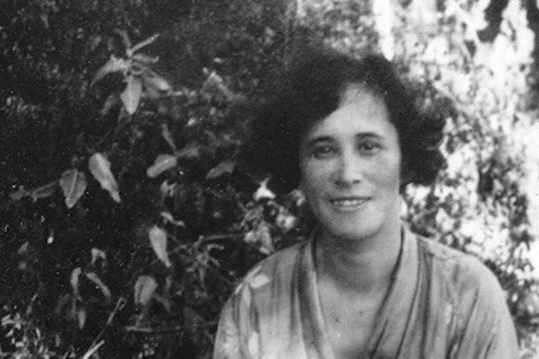 A woman seen smiling outdoors.