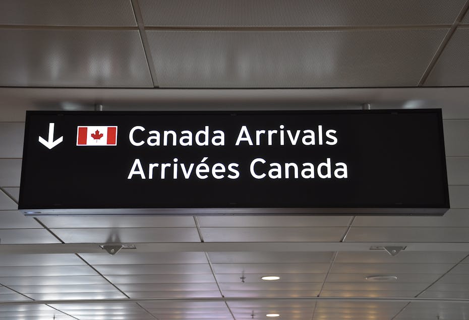 A sign at an airport that says Canada Arrivals in English and French.