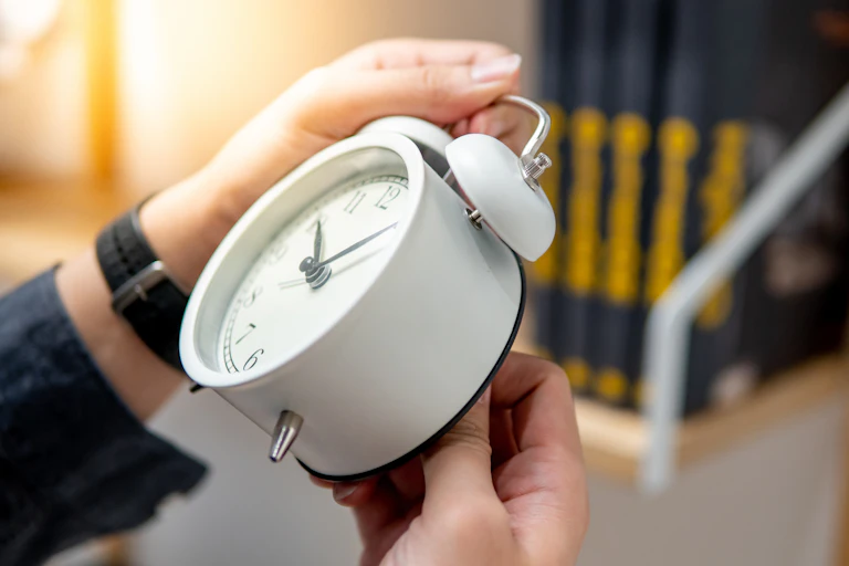 Hands setting alarm clock