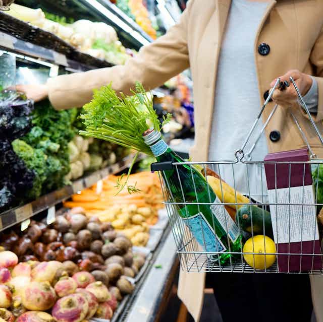 Femme en train de faire ses courses au rayon fruti et légume d'un supermarché