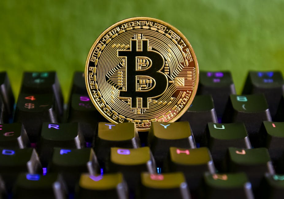 Pièce symbolisant un bitcoin sur un clavier d'ordniateur